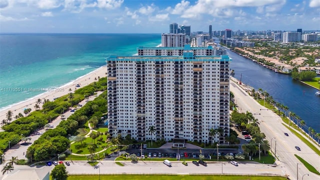 drone / aerial view featuring a city view, a beach view, and a water view