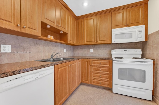 kitchen featuring light tile patterned floors, white appliances, tasteful backsplash, and sink