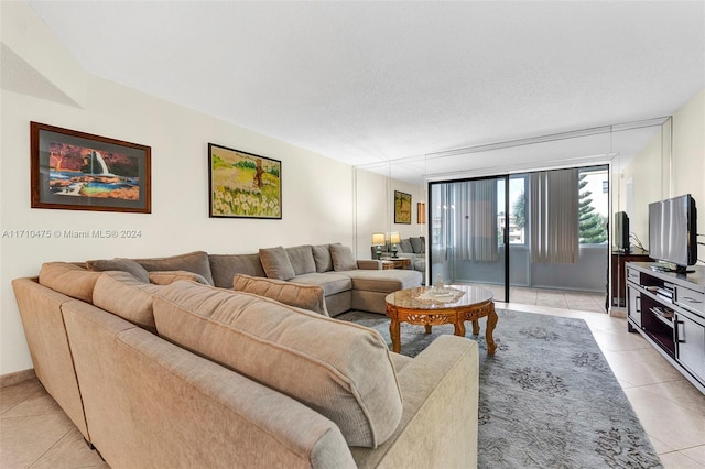 tiled living room featuring a textured ceiling