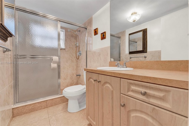 bathroom with walk in shower, vanity, tile walls, tile patterned flooring, and toilet