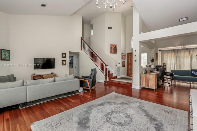 living room with a towering ceiling, wood-type flooring, and a chandelier