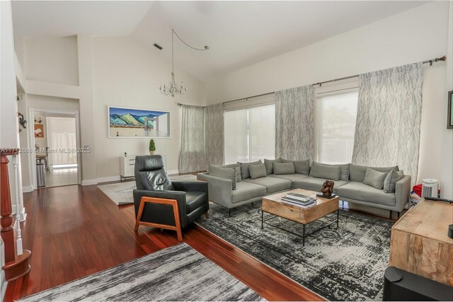 living room featuring hardwood / wood-style flooring, a chandelier, and high vaulted ceiling