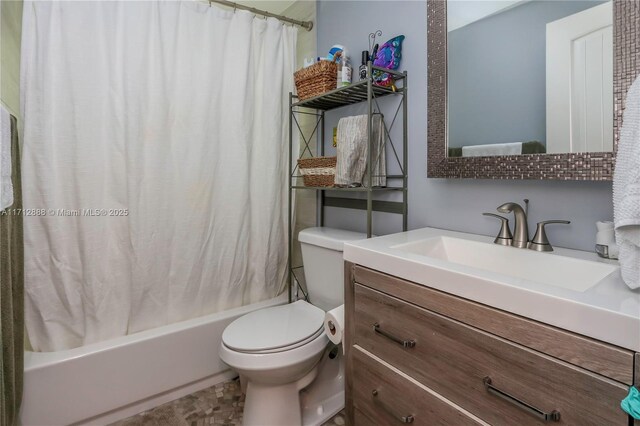 full bathroom with vanity, shower / tub combo with curtain, and toilet