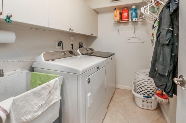 washroom with cabinets, washer and clothes dryer, sink, and light tile patterned floors