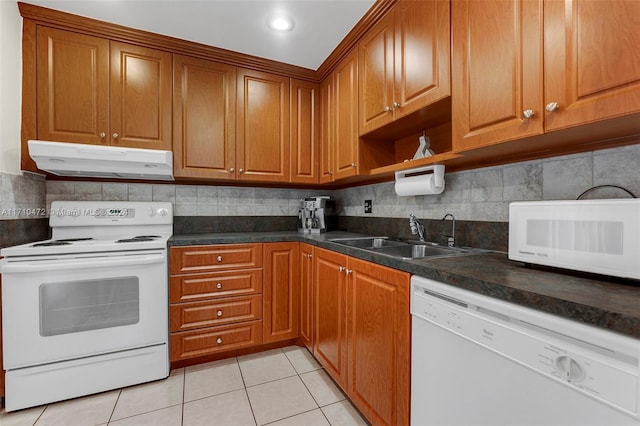 kitchen with decorative backsplash, sink, light tile patterned floors, and white appliances