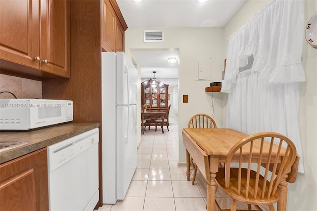 kitchen featuring light tile patterned floors and white appliances