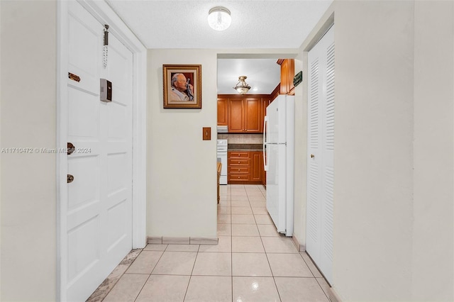 hallway with light tile patterned flooring and a textured ceiling