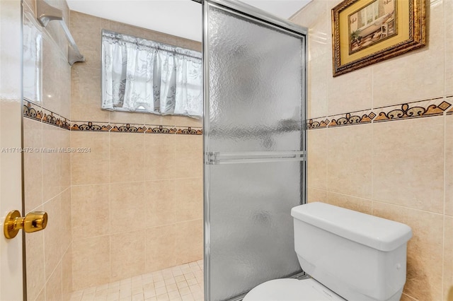 bathroom featuring toilet, walk in shower, and tile walls