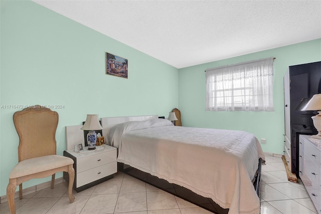 bedroom with a textured ceiling and light tile patterned flooring