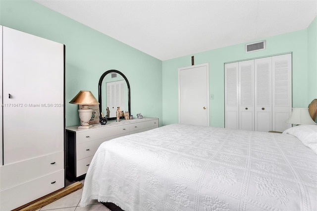 bedroom with light tile patterned floors and a closet