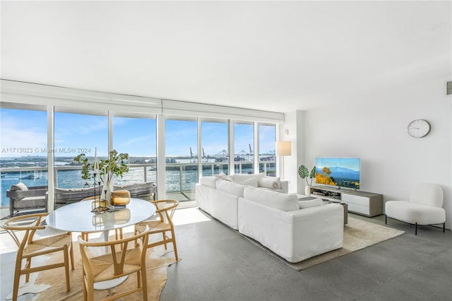 living room with a water view and concrete flooring