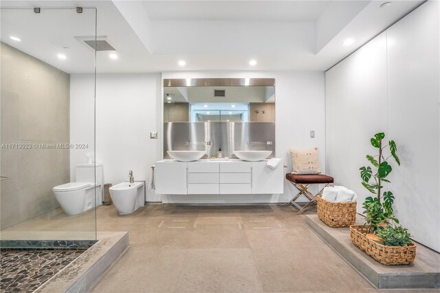 bathroom with vanity, toilet, walk in shower, and a bidet