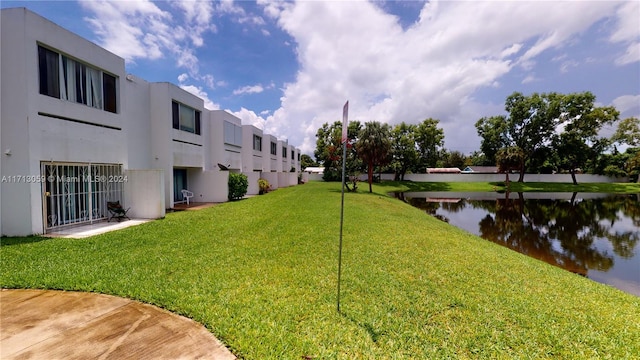 surrounding community featuring a lawn and a water view