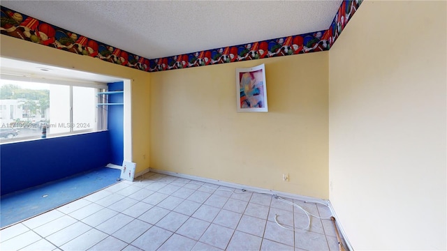 unfurnished room with light tile patterned floors and a textured ceiling