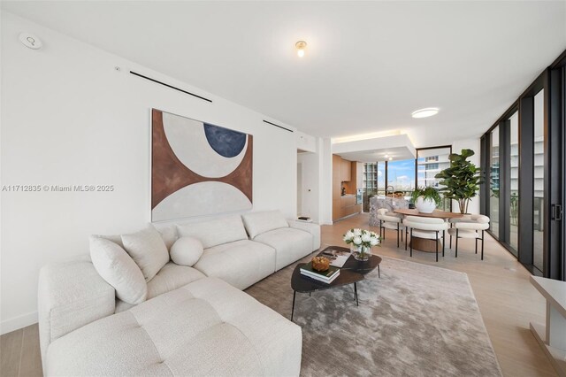 living room with hardwood / wood-style flooring and a wall of windows