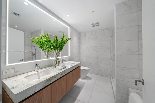 full bath with a sink, tile walls, toilet, and double vanity