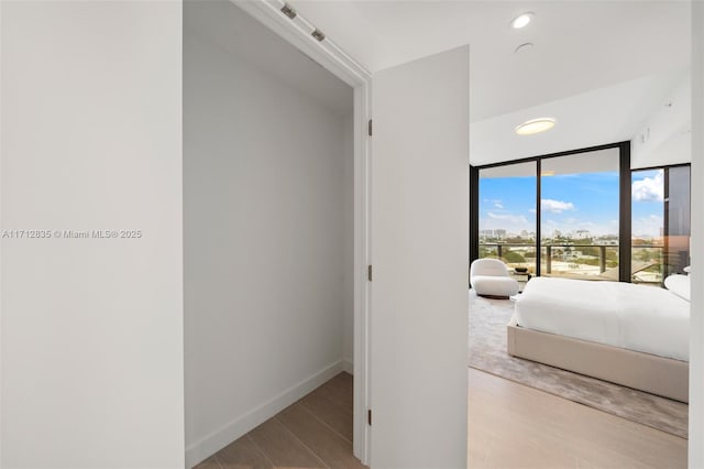 bedroom featuring access to exterior, baseboards, wood finished floors, and recessed lighting