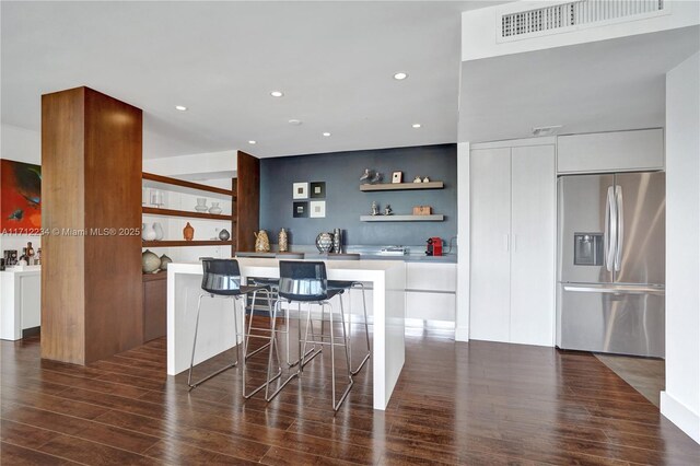 kitchen featuring white cabinetry, a kitchen island, dark wood-type flooring, and stainless steel refrigerator with ice dispenser