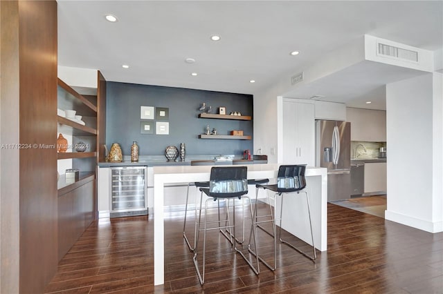 bar featuring appliances with stainless steel finishes, dark hardwood / wood-style flooring, white cabinetry, and wine cooler