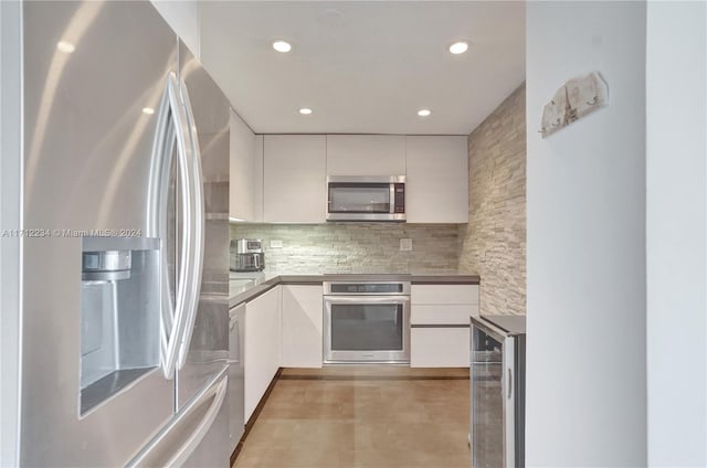 kitchen featuring decorative backsplash, white cabinetry, beverage cooler, and stainless steel appliances