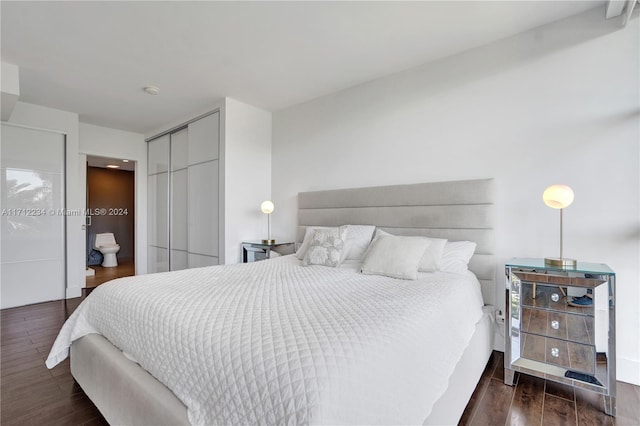 bedroom featuring connected bathroom, a closet, and dark hardwood / wood-style floors