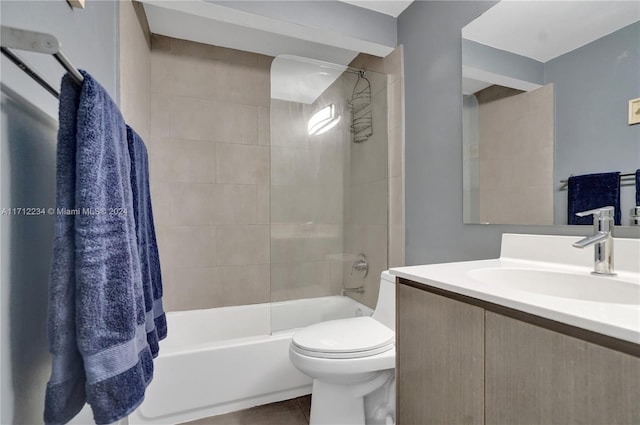 full bathroom with tile patterned floors, vanity, tiled shower / bath combo, and toilet