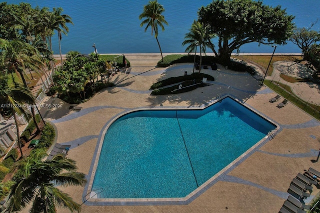 view of pool with a water view and a patio