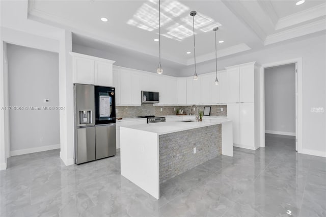 kitchen featuring white cabinets, sink, decorative light fixtures, appliances with stainless steel finishes, and a large island