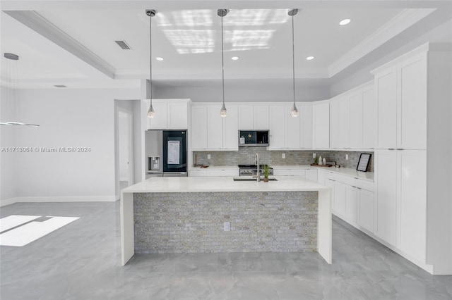 kitchen featuring appliances with stainless steel finishes, a center island with sink, white cabinetry, and hanging light fixtures