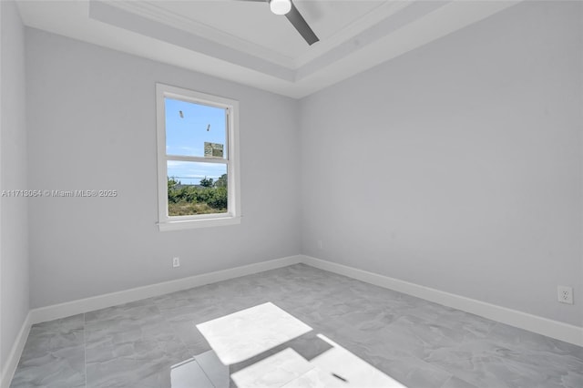 spare room featuring a raised ceiling, ceiling fan, and ornamental molding