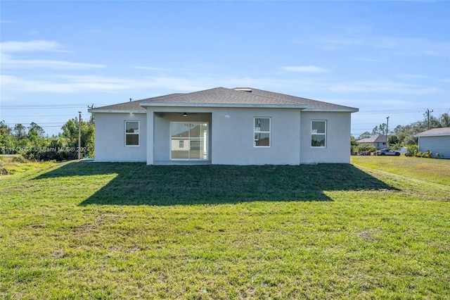 back of property featuring a lawn and ceiling fan