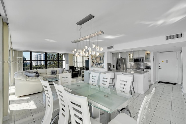 dining space with a chandelier, light tile patterned floors, and floor to ceiling windows