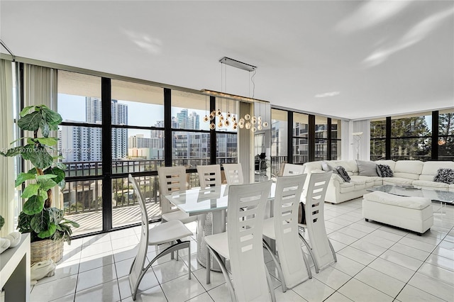 tiled dining space featuring an inviting chandelier and a wall of windows