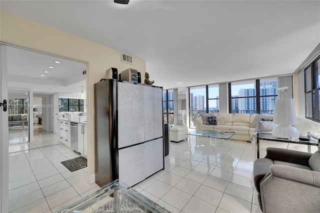 kitchen featuring light tile patterned floors, dishwasher, white cabinetry, fridge, and expansive windows