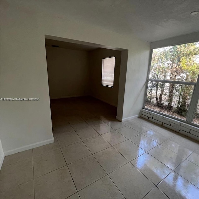 unfurnished room featuring tile patterned floors and baseboards