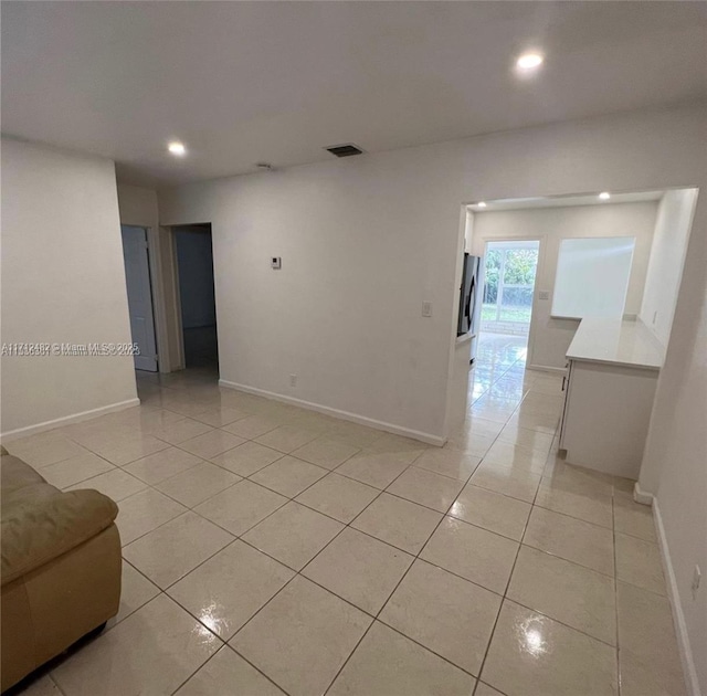 empty room with light tile patterned floors, recessed lighting, baseboards, and visible vents