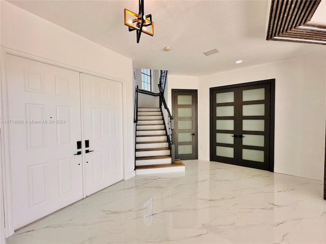 foyer entrance with french doors and a textured ceiling