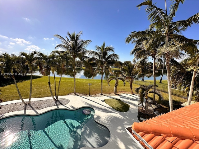 view of swimming pool featuring a water view and a yard