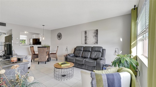 tiled living room featuring plenty of natural light and a textured ceiling