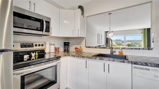 kitchen with white cabinetry, sink, backsplash, decorative light fixtures, and appliances with stainless steel finishes