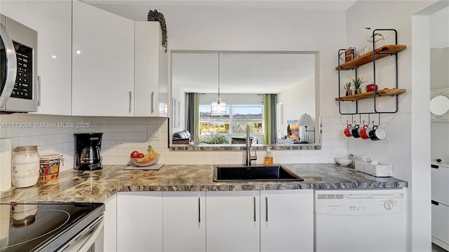 kitchen with dishwasher, backsplash, white cabinets, and sink