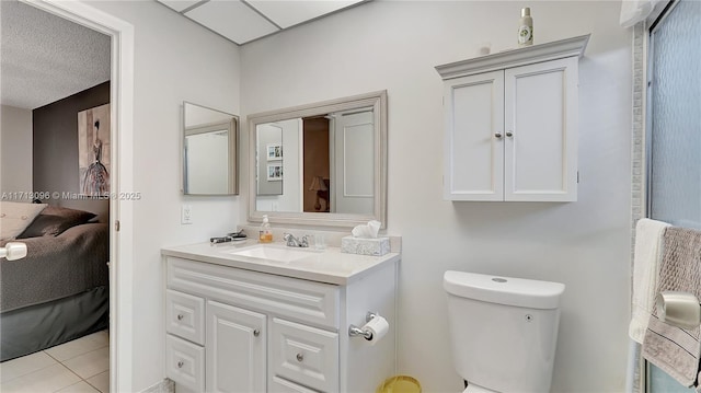 bathroom with tile patterned flooring, vanity, a textured ceiling, and toilet