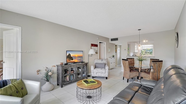 living room featuring light tile patterned flooring, a textured ceiling, and a chandelier