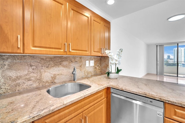 kitchen featuring tasteful backsplash, dishwasher, sink, and light stone counters