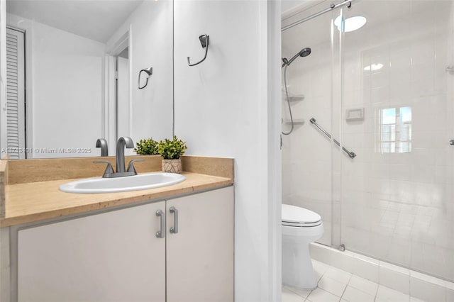 bathroom featuring vanity, toilet, tile patterned floors, and a shower with shower door