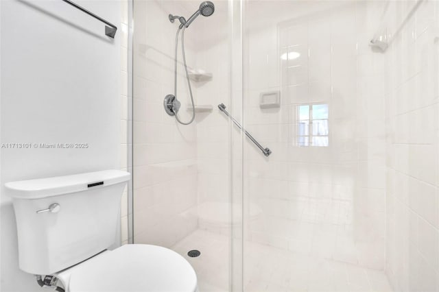 bathroom featuring tiled shower and toilet