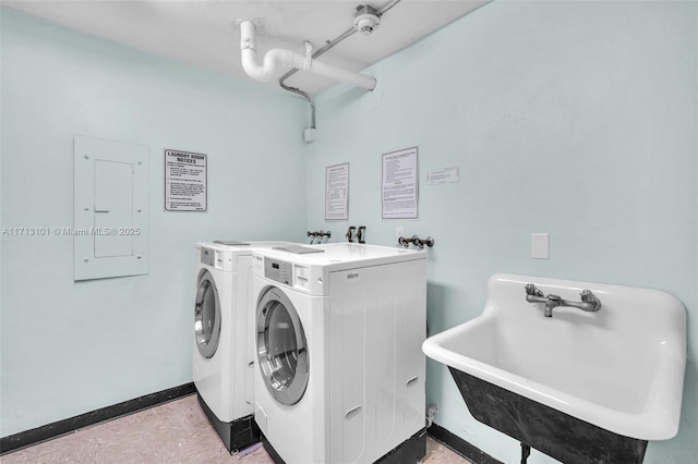 clothes washing area with electric panel, washer and clothes dryer, and sink