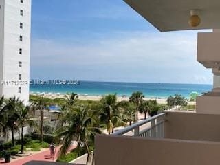 balcony with a water view and a beach view