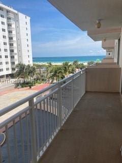 balcony featuring a water view and a view of the beach