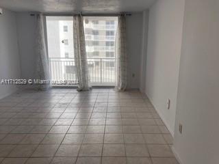 tiled spare room with a wall of windows